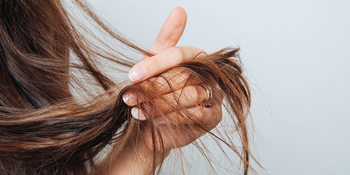 Girl holding her hair in her hand. Hair care concept. Shampoo. Haircut needed.